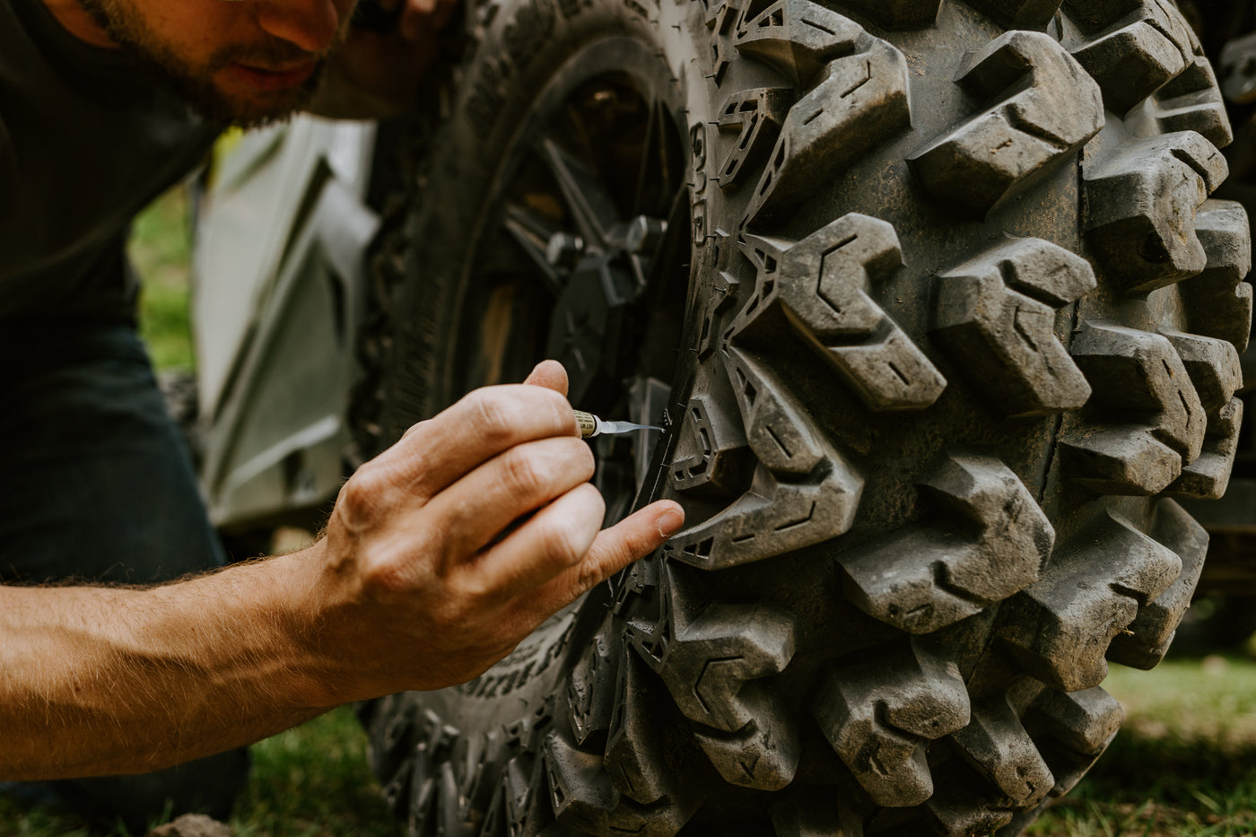 Applying GlueTread adhesive to an off-road tire during a trail-side repair