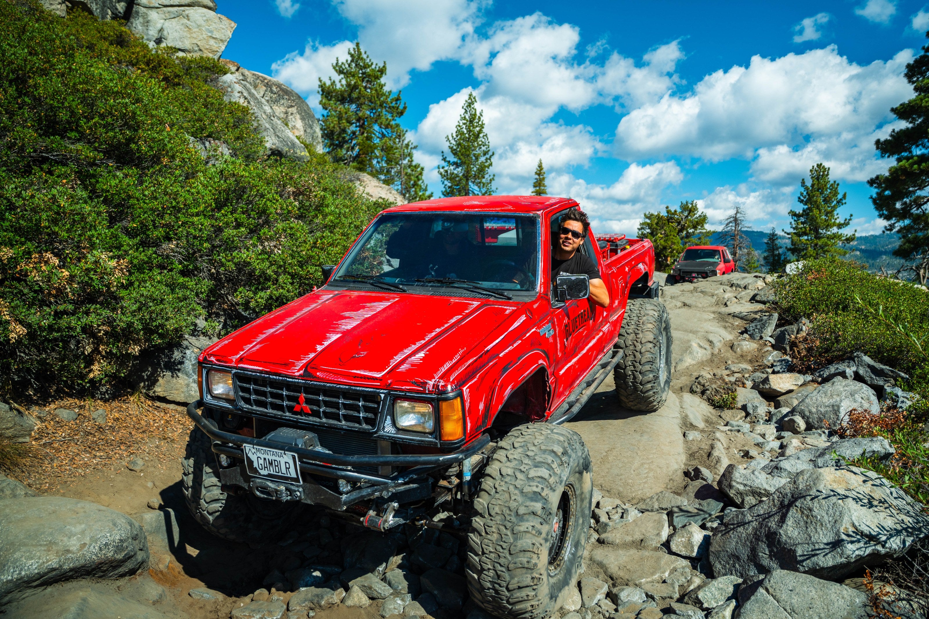 GlueTread 4x4 pickup climbing a rocky trail under blue sky